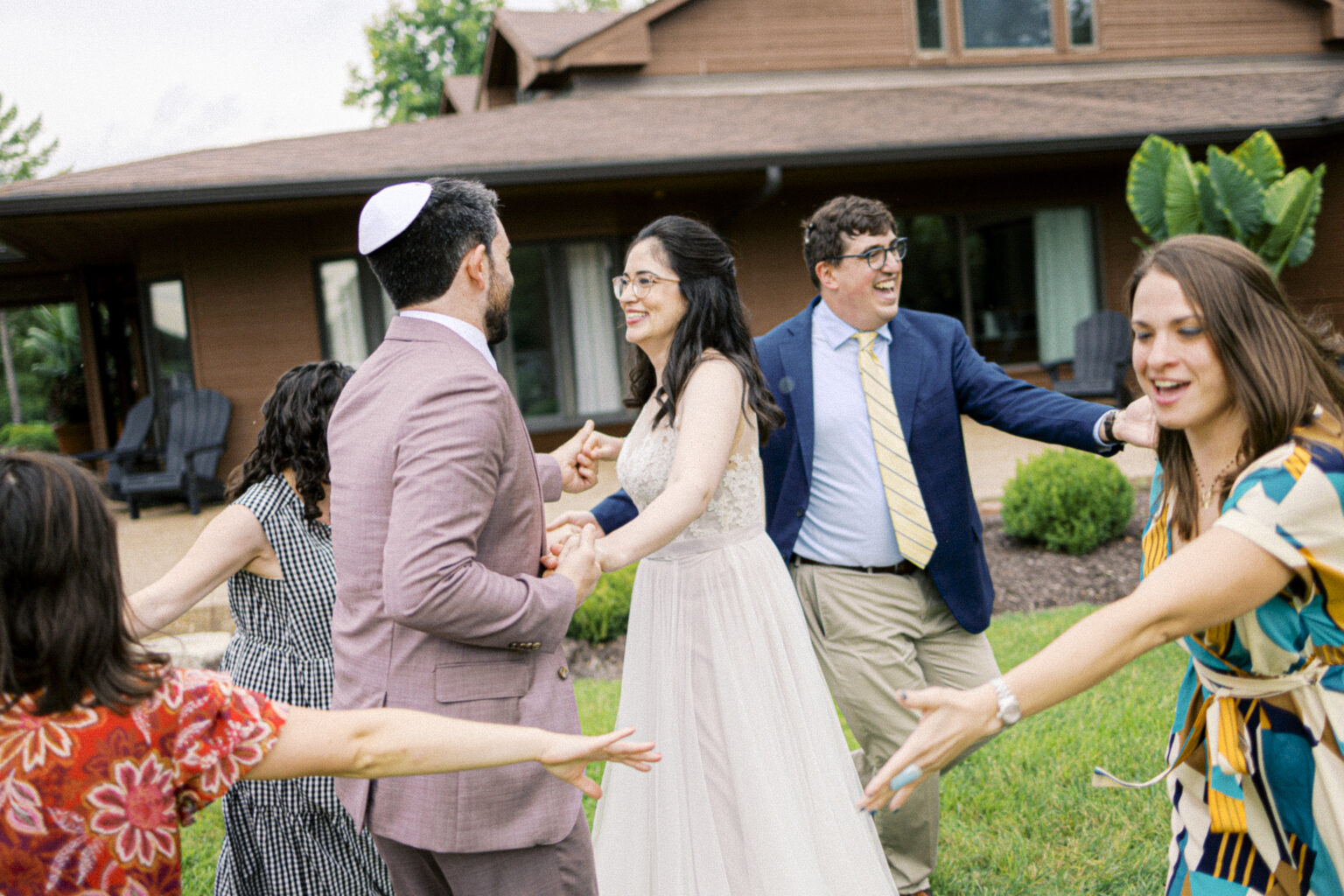 Guests gathered in a circle, dancing and singing around the bride and groom, celebrating joyfully after the ceremony.