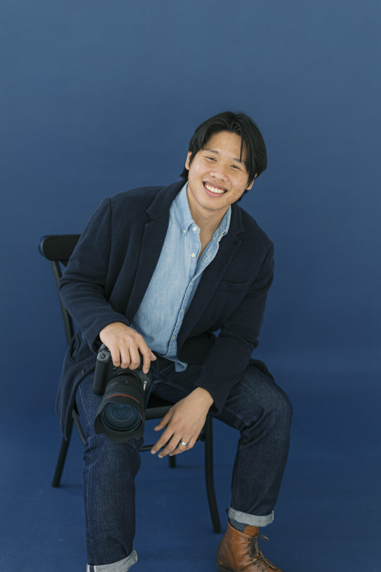 James Tananan portrait, sitting with his camera, ready to meet clients for the first time.