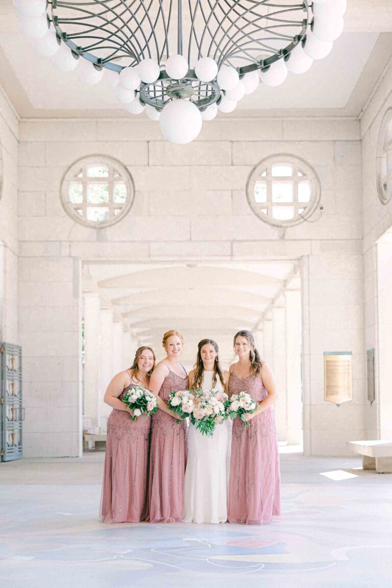 Bride standing with her bridesmaids at Muny Forest Park in St. Louis, all facing the camera in a clean and polished group portrait.